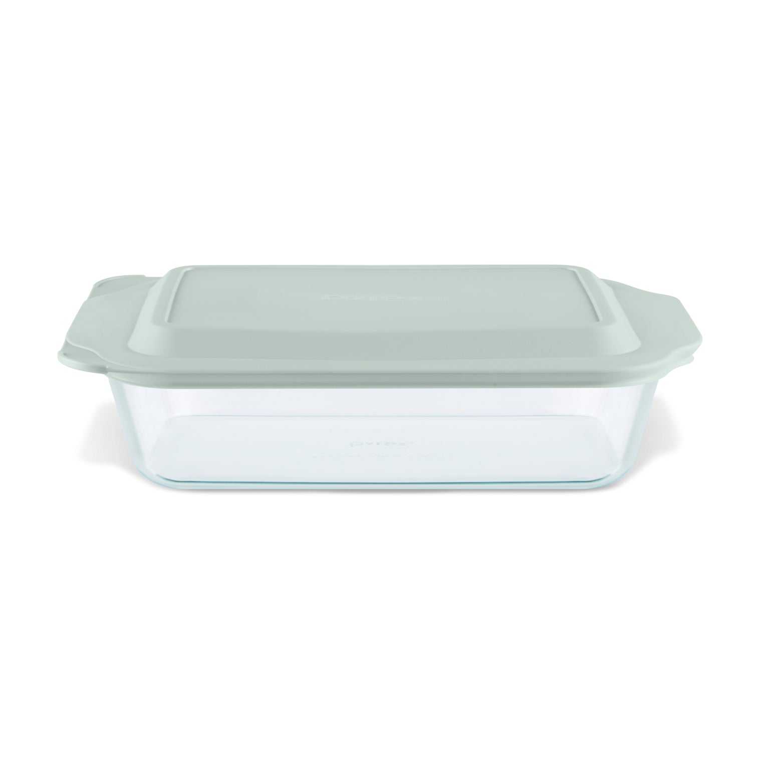 Glass baking dish with a green lid on a white background