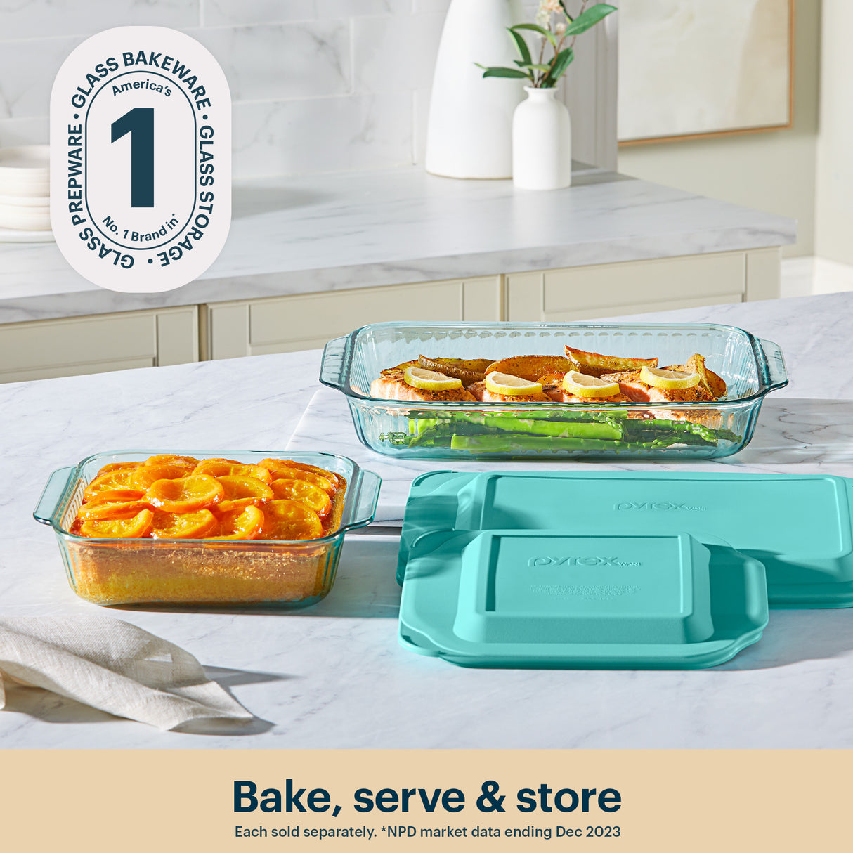 Glass bakeware set with teal lids on a kitchen counter, featuring Pyrex branding.