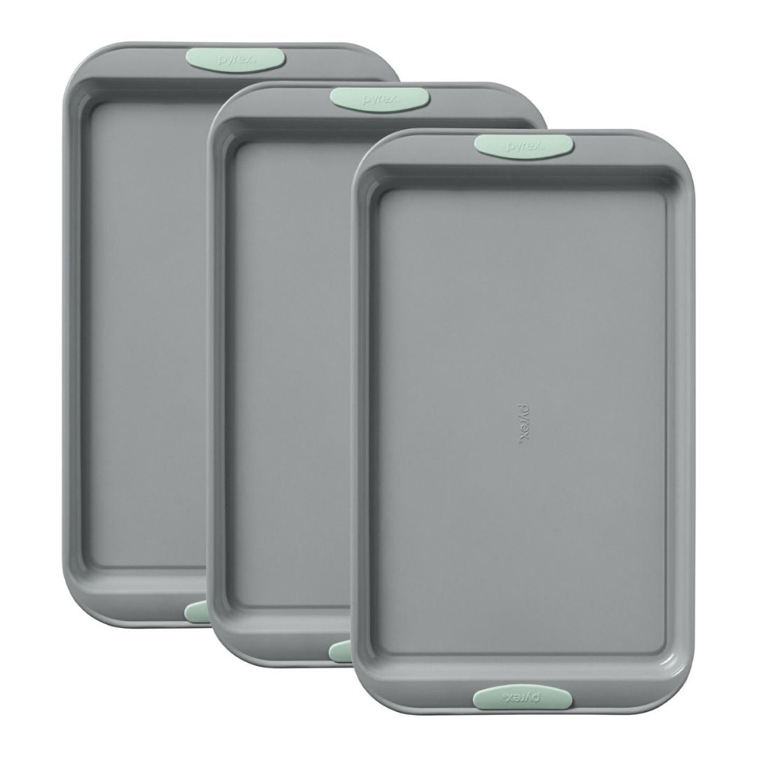 Three gray baking trays with green edges on a white background