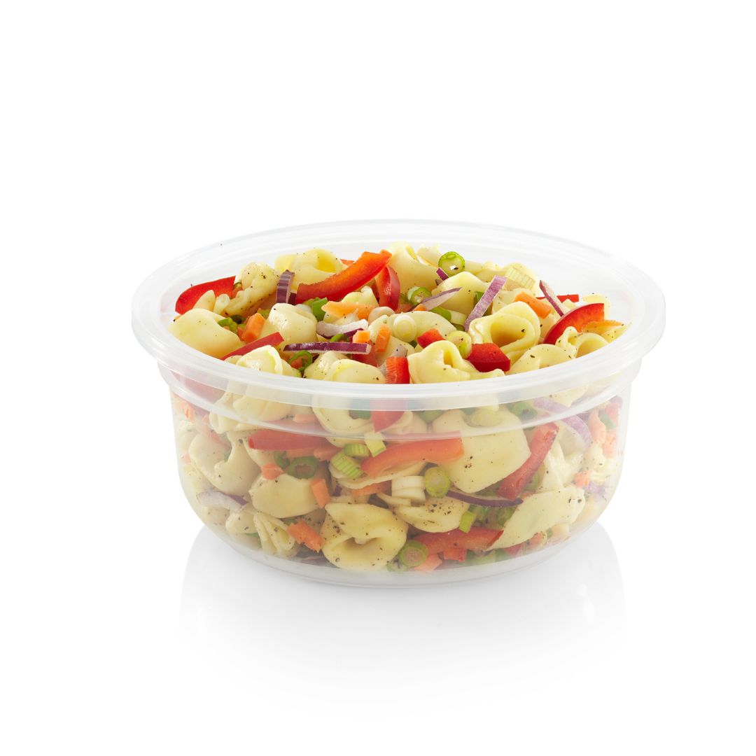 Clear plastic container filled with colorful pasta salad on a white background