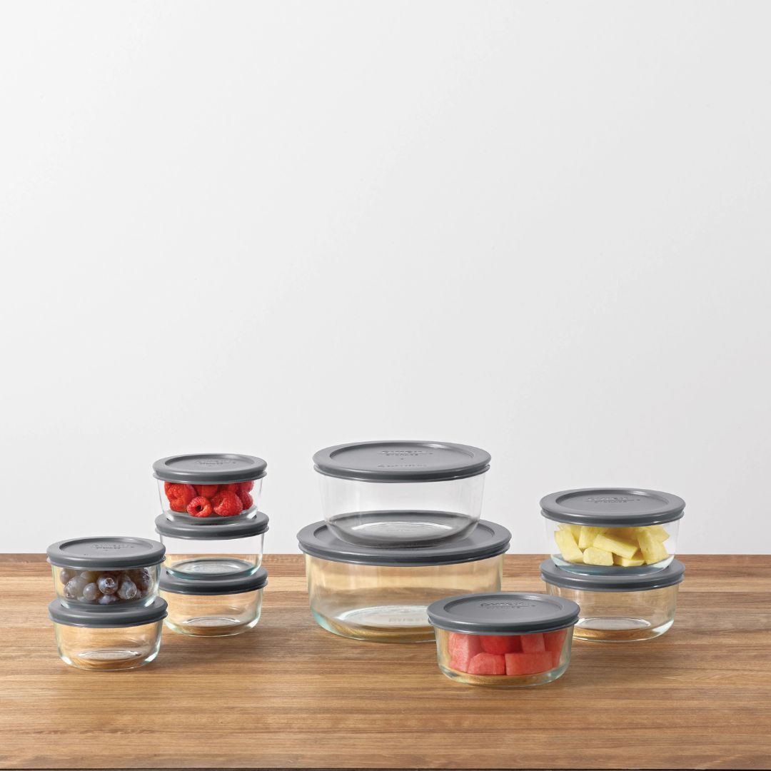 Set of glass containers with gray lids on a wooden surface